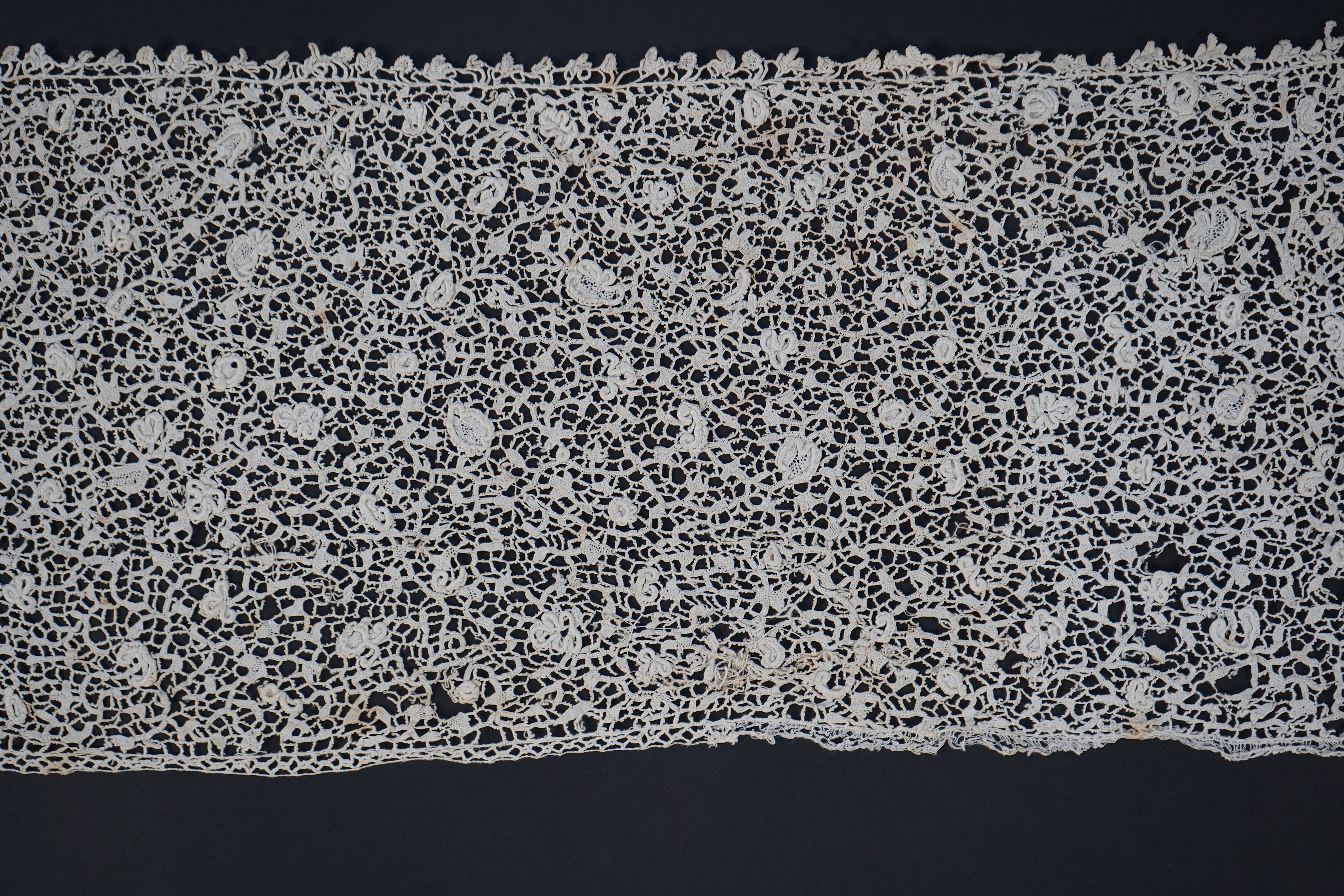 A late 17th century wide flounce of Point de France needle lace, together with a narrower flounce, both with raised elements of the design in the style of Point de Rose, but less so. This lace was very popular with the F